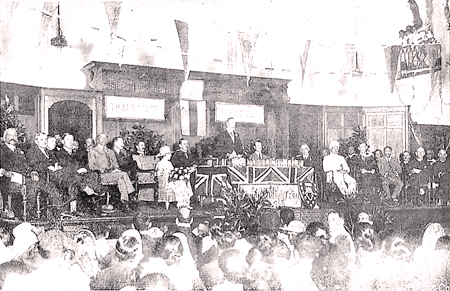 Governor Sir William Manning addressing the elegantly clad audience. On his right is Principal H.L. Reed, the lady with the bouquet is Mrs. Manning or  Mrs. Reed.  Sir Ponnambalam Ramanathan may be identified in a Turban.