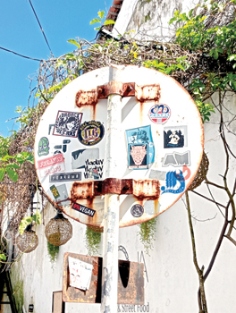 A street sign decorated with stickers