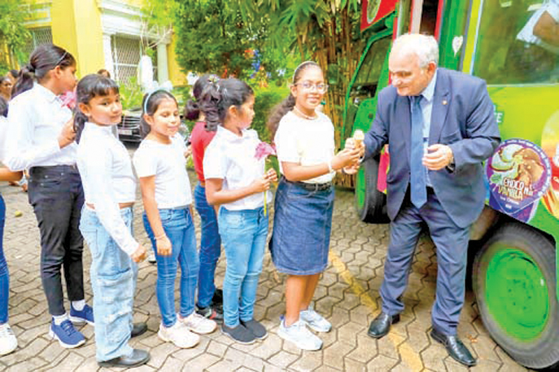 Russian Ambassador in Sri Lanka Levan Dzhagaryan distributing ice cream to children at a dansala at the Russian Centre in Colombo