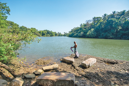 A fallen stone pillar on the bank of the Kelana Ganga near the temple, which is used by villagers to wash linen