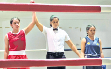 Kalani Herath (left) from Gateway International is declared the winner over DWK Lakmali (right) of Batuhena MV by referee Samudra Bandara in the final of the girls Under-54 kgs at the Donald Munasinghe boxing meet held recently in Nawalapitiya. Kalani was adjudged the best boxer