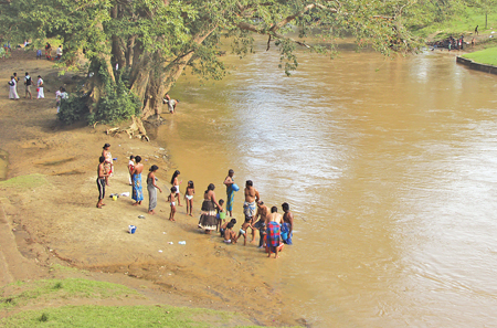 Devotees bathe in the Menik Ganga