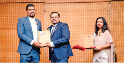 President Chrishanthus Perera presents a token of appreciation to motivational speaker and Toastmaster Club Growth Director Bathiya Hettiarachi.