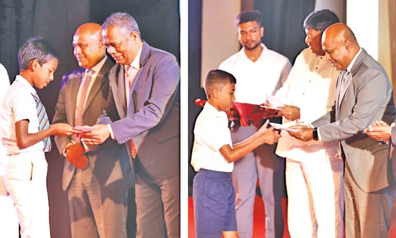 Children receiving scholarship awards from People’s Bank officials